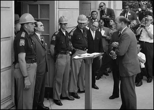 Governor George Wallace stands defiantly at the door University of Alabama while being confronted by Deputy U.S. Attorney General Nicholas Katzenbach on 11th July 1963.