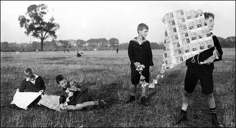German children are photographed launching a kite made of worthless banknotes