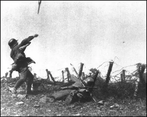A German soldier throws a stick grenade during an attack on Allied trenches in 1918. He carries no other weapon and is protected by a rifleman who carries extra grenades.