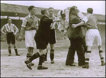 Ted Drake being carried off unconcious by Tom Whittaker in the match against Brentford on 18th April, 1938