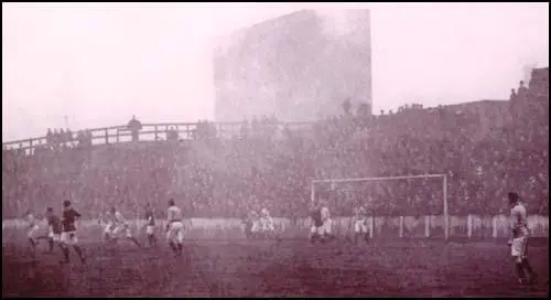 Manchester United playing a home game against Portsmouth in January 1907.The smoke was created by the chimneys of the adjacent chemical works.