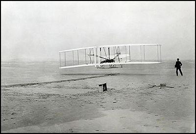 Orville Wright, watched by Wilbur Wright, pilotsthe Flyer in its first flight on 17th December, 1903