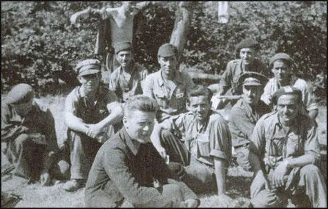 Sam Wild wearing a beret is kneeling on the right of the picture.