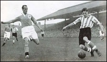 Harry Johnston of Blackpool tries to block a shot by Len Shackleton