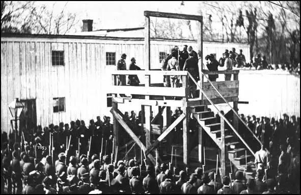 This photograph taken by Alexander Gardner shows Major Russell reading the death warrant to Henry Wirz on the gallows at Washington Penitentiary.