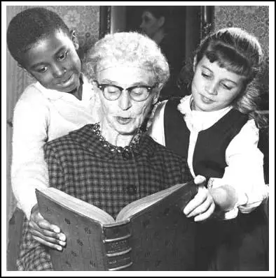 Jessie Binford teaching two children to read.